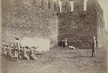 A British firing squad executes Burmese 'rebels' outside the walls of Mandalay.
