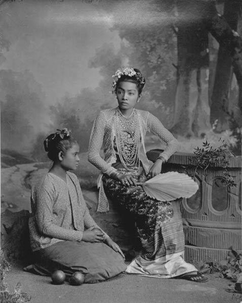 "A Burmese lady, her servant, and two citrus fruits"