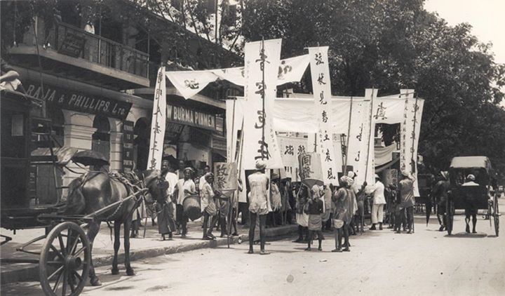 ၁၉၃၀ ပြည့်နှစ် ဝန်းကျင်က ရန်ကုန်မြို့တွင် တရုတ်သင်္ကေတပါ ဆိုင်းဘုတ်များ သယ်ဆောင်ထားသော အိန္ဒိယလူမျိုးများ